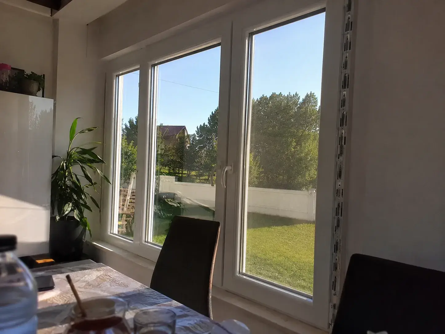 Beli PVC prozori sa tri krila u trpezariji, pogled na dvorište