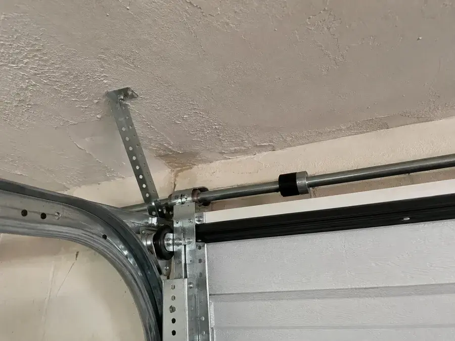 Pogled iznutra garaže na unutrašnji mehanizam vrata pri plafonu