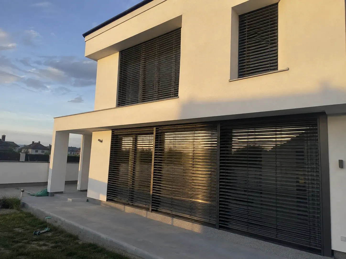 Spoljašnje rafstore žaluzine na modernoj kući u zalazak sunca