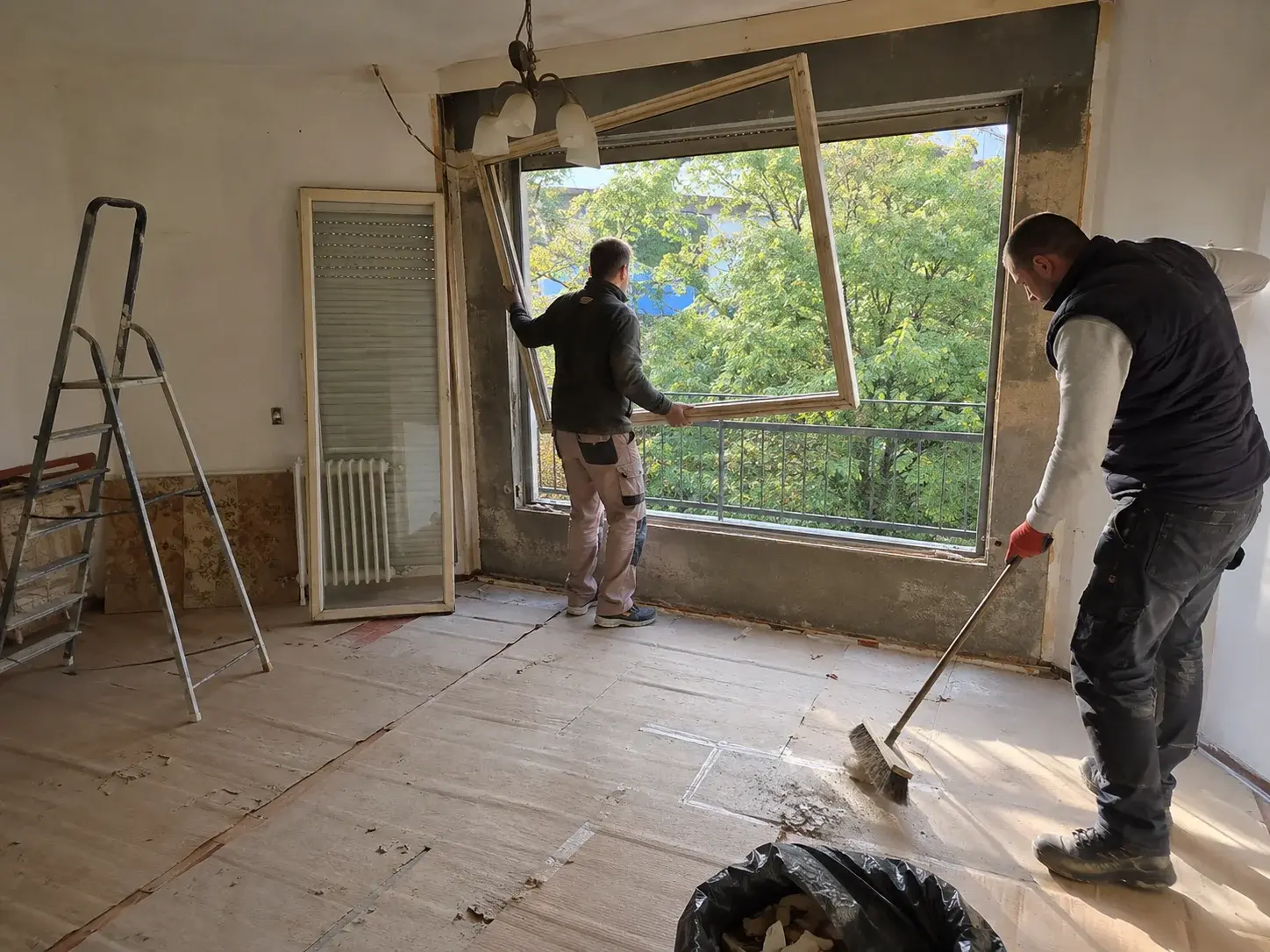 Iznošenje starog prozora iz stana tokom zamene stolarije