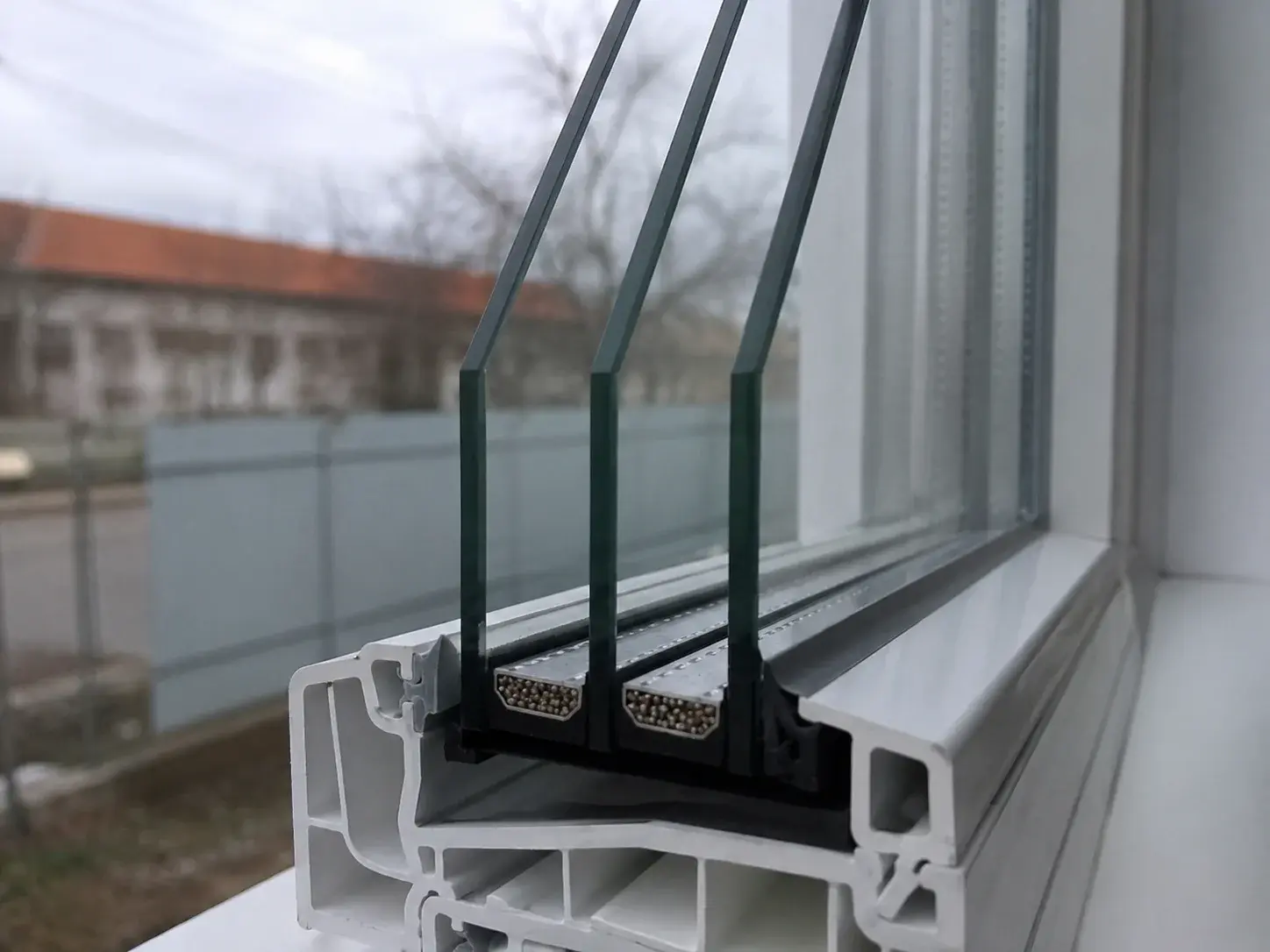Detalj troslojnog stakla sa tri stakla i dva distancera u PVC ramu